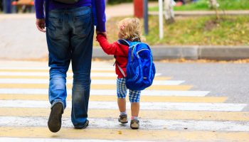 father with little daughter walking to school or daycare